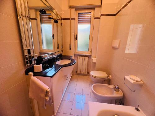 a bathroom with a sink and a toilet and a mirror at Suite Excelsior - Bordighera in Bordighera