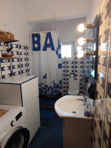 a bathroom with a sink and a toilet and a shower curtain at Fiorela Gest House in Kalabaka