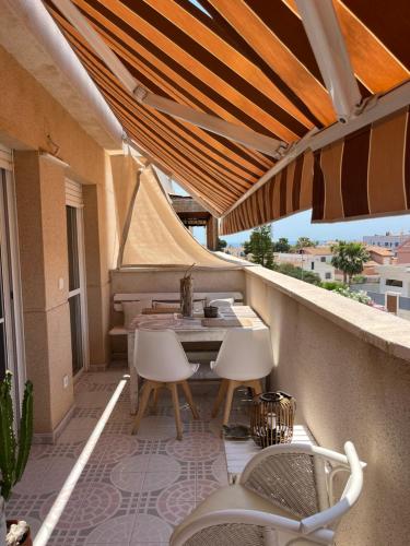 a patio with a table and chairs on a balcony at Lydia Cabo Cope in Calabardina