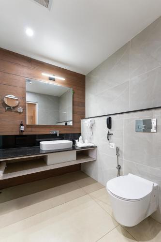 a bathroom with a toilet and a sink and a mirror at Lords CBC Plaza Chitwan in Bharatpur