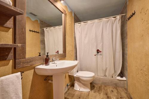 a bathroom with a sink and a toilet and a mirror at Pirates Village in Santa Ponsa
