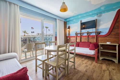 a living room with a table and chairs and a bed at Pirates Village in Santa Ponsa