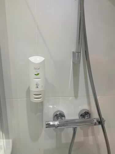 a bathroom with a sink with a soap dispenser at Elysee Hyde Park in London