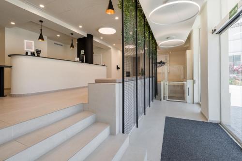 a lobby of a building with stairs and a counter at Hotel Coral Boutique by gaiarooms in L'Estartit