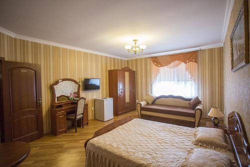Schlafzimmer mit einem Bett, einem Schreibtisch und einem Fenster in der Unterkunft Goldenluxe in Berehowe