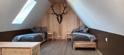 a attic room with two beds and a table at Staltbrieži in Ratnieki
