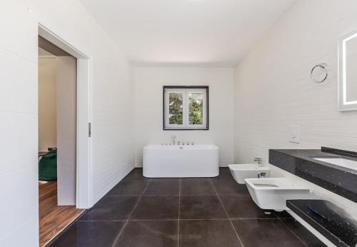 a white bathroom with two sinks and a tub at Fllad e Valë Luxury Private Pool Villa by PikHost in Tragjas