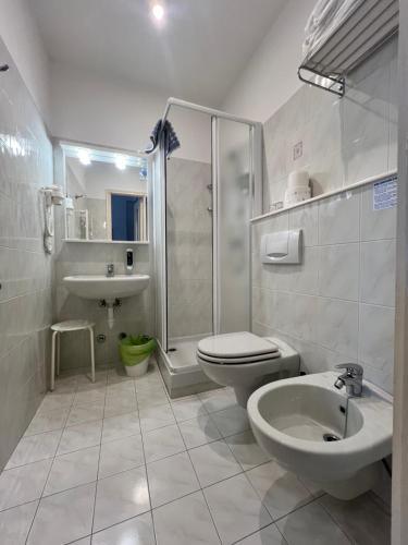 a bathroom with a shower toilet and a sink at Hotel Tirreno in Alassio