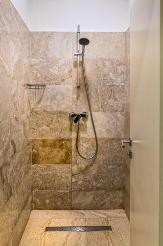 a shower with a shower head in a bathroom at TURQUOISE Hostel in Bucharest