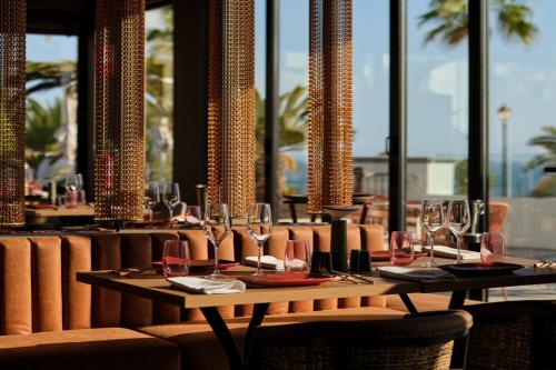 a table with wine glasses on it in a restaurant at Bahia Principe Escape Tenerife - Hyatt Inclusive Collection in Adeje
