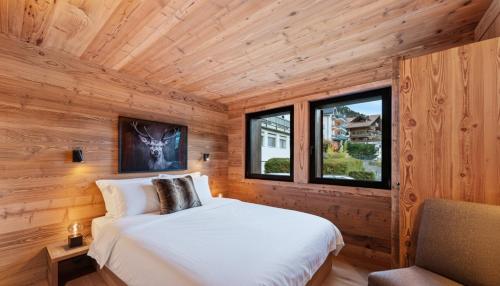 a bedroom with a bed in a log cabin at Chalet Dents Blanches - Latitude Champéry in Champéry