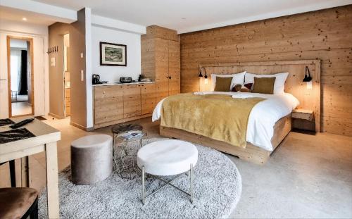 ein Schlafzimmer mit einem großen Bett und einer Holzwand in der Unterkunft John's Lodge in Les Collons