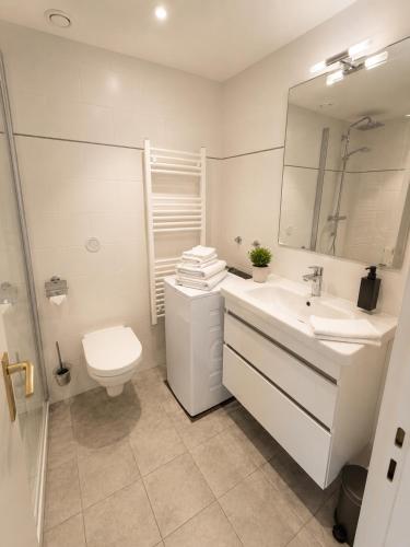 a white bathroom with a toilet and a sink at Timmendomizil - schöne Ferienwohnung in bester Lage - Sonnenseite in Timmendorfer Strand