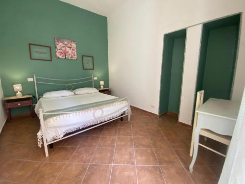 ein Schlafzimmer mit einem Bett und grünen Wänden in der Unterkunft DaLiù in Itri