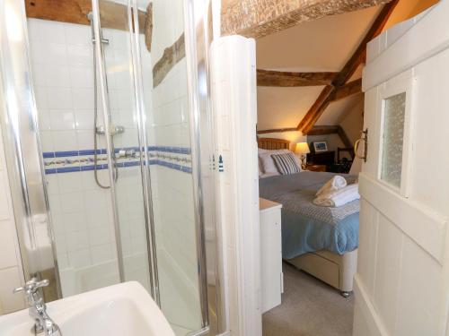 a bathroom with a shower and a bed and a sink at Tovah in Yarmouth