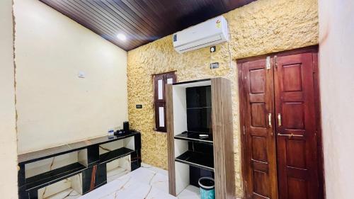 a room with two wooden doors and a heater at The Ocean Crown in Udupi