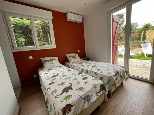 a bedroom with two beds and a window at Bidart, maisonnette sur les Pyrénées in Bidart