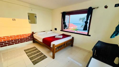 a bedroom with a bed and a window at The Ocean Crown in Udupi