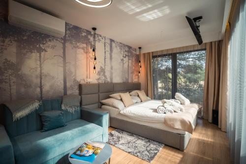 a bedroom with a bed and a couch at Bodrogi Kúria Wellness Hotel in Inárcs