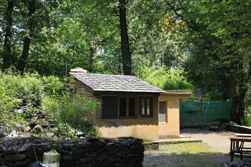 a small building in the middle of a garden at NotOnMap- Saal River Homestay in Chamba