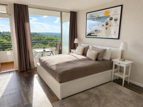 a bedroom with a bed and a large window at Timmendomizil - schöne Ferienwohnung in bester Lage - Sonnenseite in Timmendorfer Strand