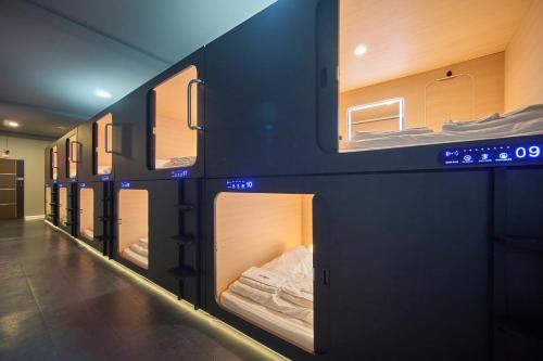 a row of bunk beds in a room at Urban Pod Capsule Hostel in Bangkok