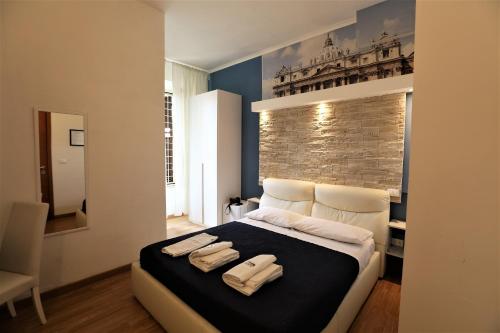 a bedroom with a large bed with two towels on it at Rooma Beb in Rome