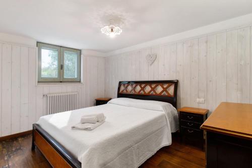 a bedroom with a bed with white sheets and a desk at La Mansarda di Cecè in Ostuni