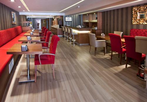 a restaurant with red chairs and tables and a bar at Nanda Hotel in Istanbul