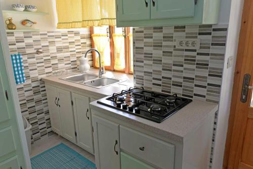una cucina con fornelli e lavello di Roberto Apartments a Veli Lošinj (Lussingrande)