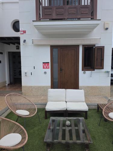 two white chairs and a table in front of a building at Refugio Costa Teguise - Lanzarote in Costa Teguise