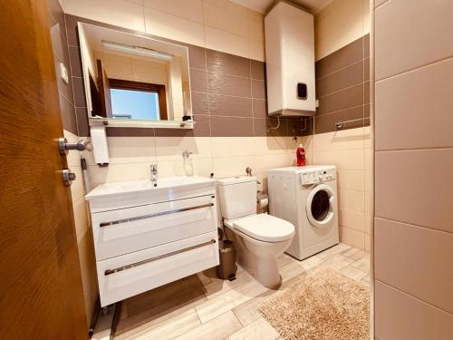 a bathroom with a toilet and a washing machine at Altezza Premium Breathtaking Sea Views in Budva