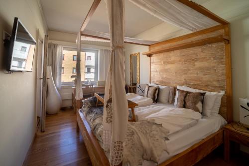 a bedroom with a large bed with a canopy at Oslo Guldsmeden in Oslo