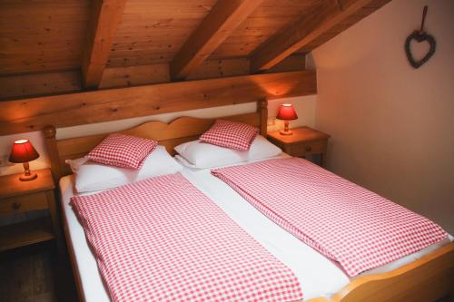 a bedroom with two beds with red and white checked pillows at Ferienwohnung Alpenwelt in Mittenwald