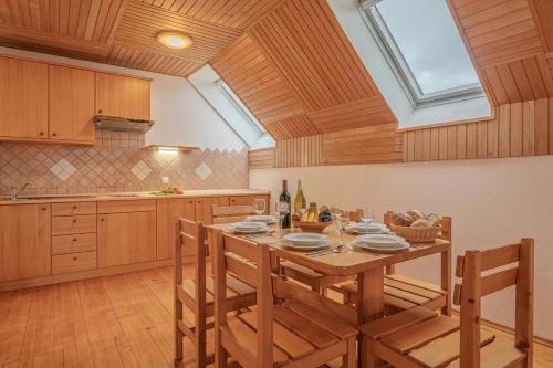 a kitchen with a table with chairs and a window at Oblak Estate Apartments in Ortnek
