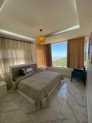 a bedroom with a large bed and a large window at Alreem Farm in Ajloun
