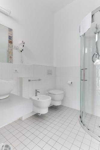 a white bathroom with two toilets and a shower at Hotel Simon in Gatteo a Mare