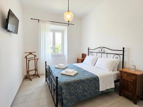 a bedroom with a bed with a blue and white blanket at Da nonno Carlo Lakeview - By BorgoLago in Capodimonte