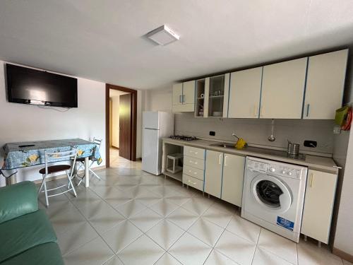 a kitchen with a washing machine and a table at LB Guest House in Tagliacozzo