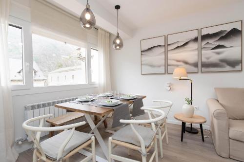 a dining room with a table and chairs and a couch at Sky Biescas II by BeValle in Biescas