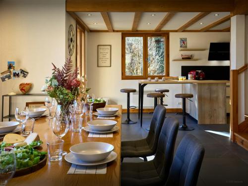 a dining room with a wooden table and chairs at Chalet Aravista - OVO Network in Le Grand-Bornand