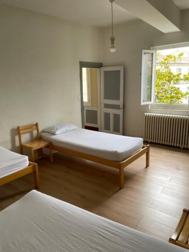 a room with two beds and a chair and a window at Gîte de la cathédrale 2 in Condom