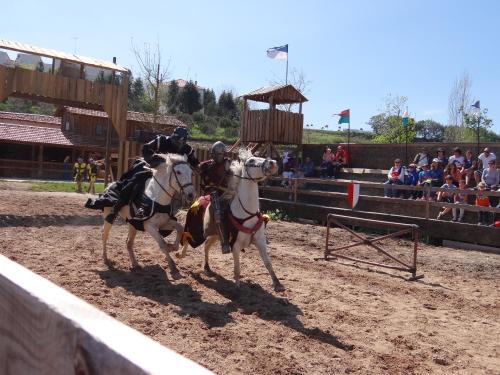 a man riding on the back of two horses in an arena at That Little Place in Batalha in Batalha