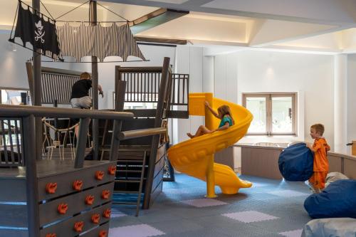 a room with two children on a slide in a play room at Cape Panwa Hotel Phuket in Panwa Beach