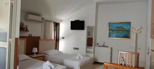 a hotel room with two beds and a television at Lille France Apartments in Shkodër