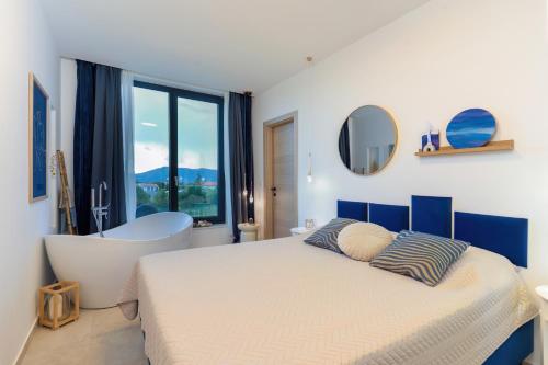 a bedroom with a large bed and a bath tub at Villa Elementa Krk - Luxury Four Elements Experience in Krk