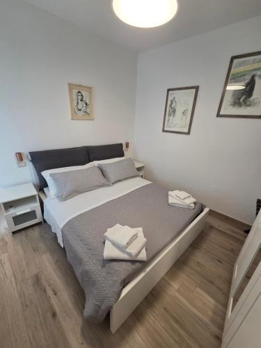 a bedroom with a bed with two towels on it at Casa del nonno Gino in Pietrasanta