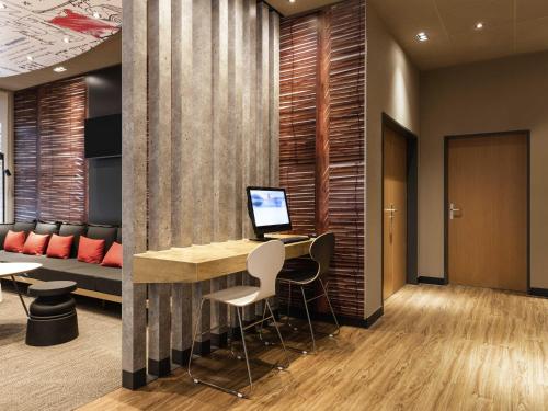a lobby with a desk with a computer on it at ibis Winterthur City in Winterthur