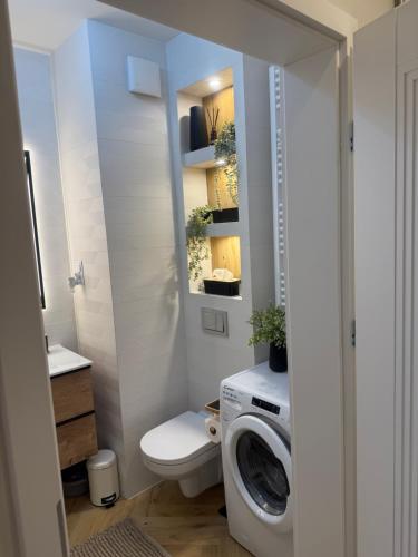 a bathroom with a toilet and a washing machine at Apartament Anna De Lux z tarasem Zamość-Roztocze in Zamość
