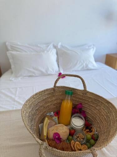 a basket with food and a bottle of juice on a bed at Mar-Ria 4 in Fuzeta